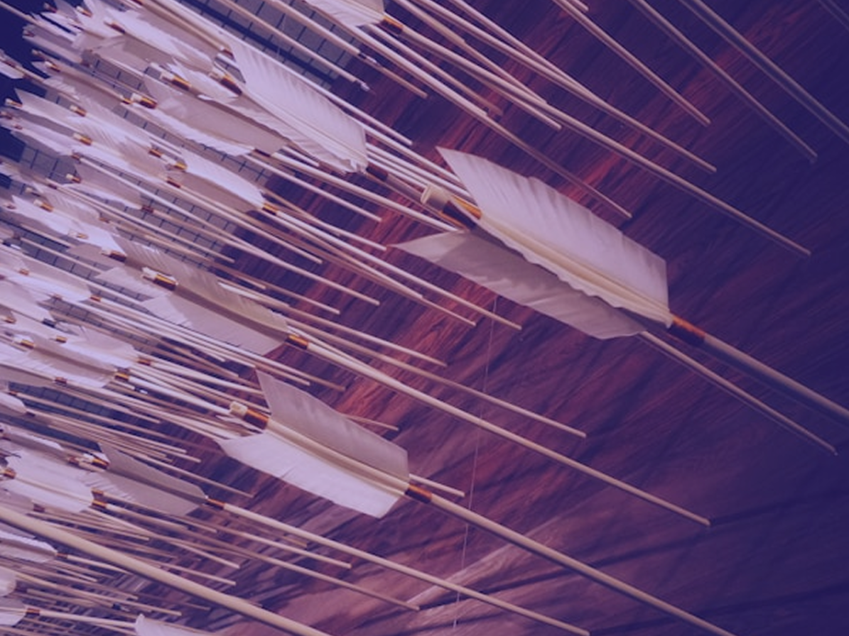 A dense volley of feathered arrows in flight, tinted purple
